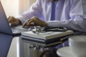 Medical pratitioner taking online coures on a laptop.