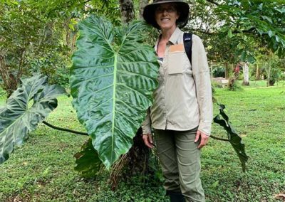 Dr. Jill Crista standing next to a ginat leaf in the Amazon Forest.